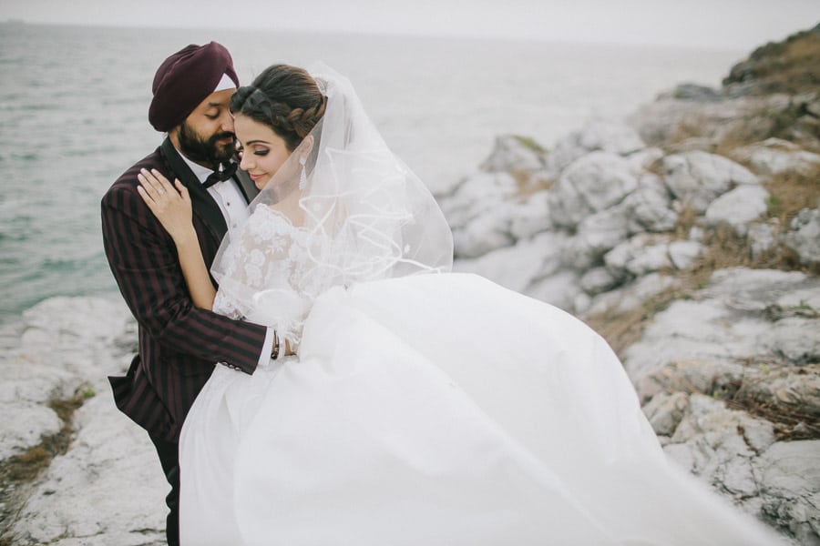 Prewedding wedding dress indian on the rocks at the sea sky