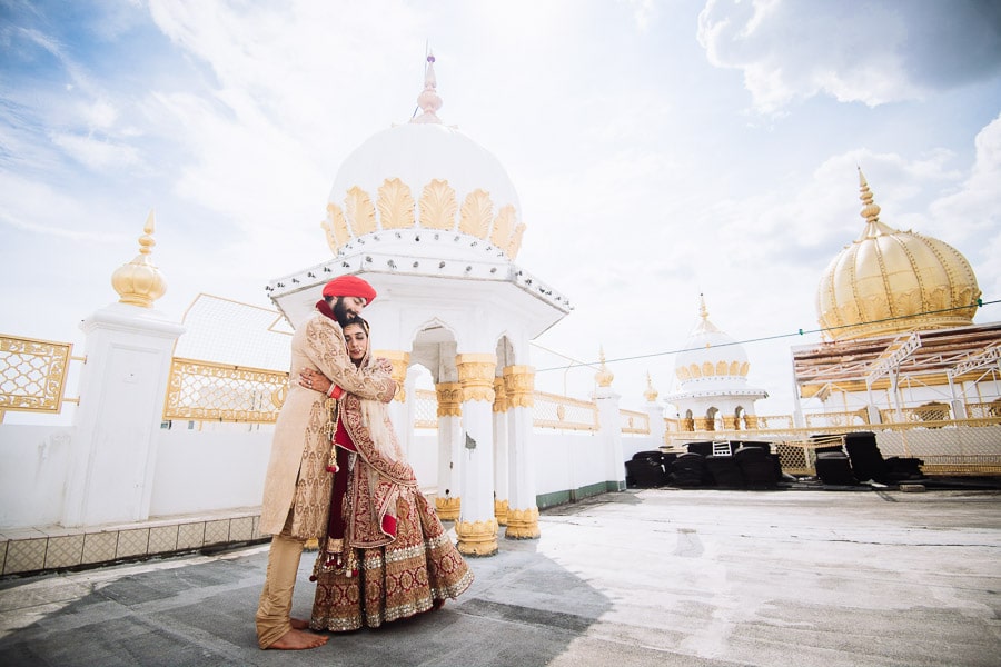 Indian wedding Bride and groom hug in temple Landscape