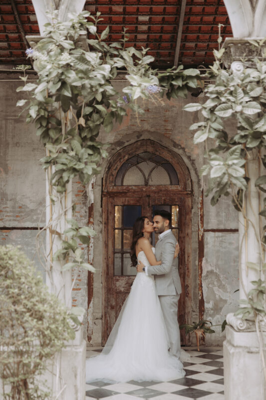 Simran and Jasras under stone arches during pre wedding photoshoot in Bangkok at Benedict Studio